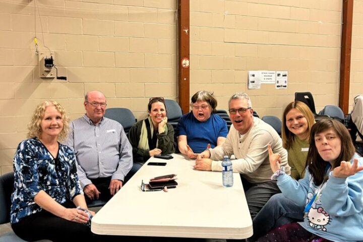 A group of people are sitting at a table at the CLGW Dance Party event
